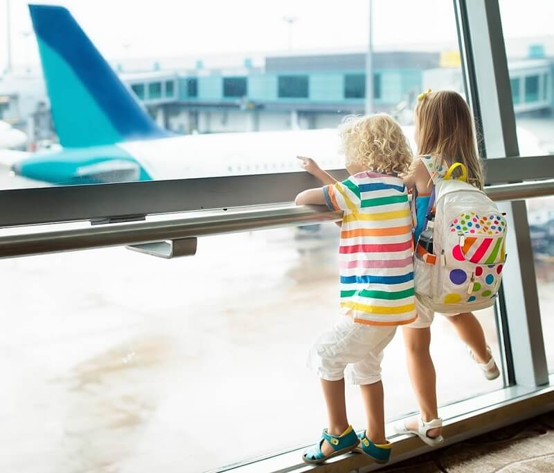 Crianças em aeroporto olhando o avião