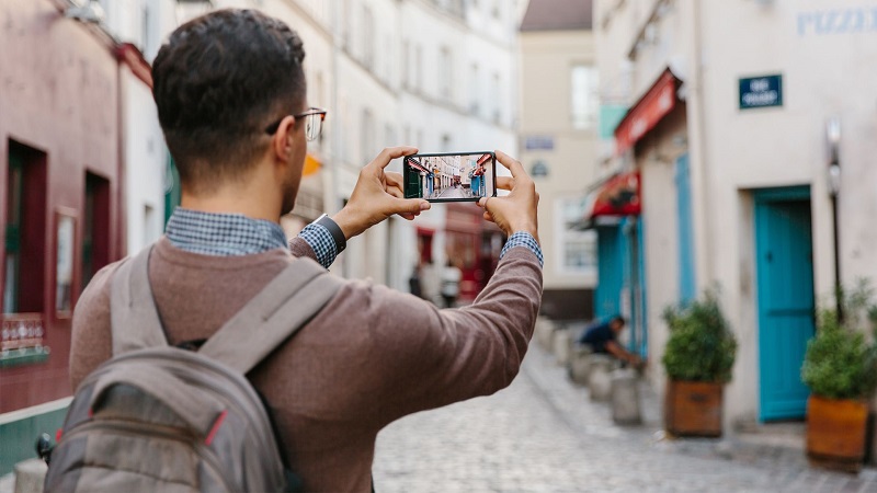 Turista tirando fotos com o celular