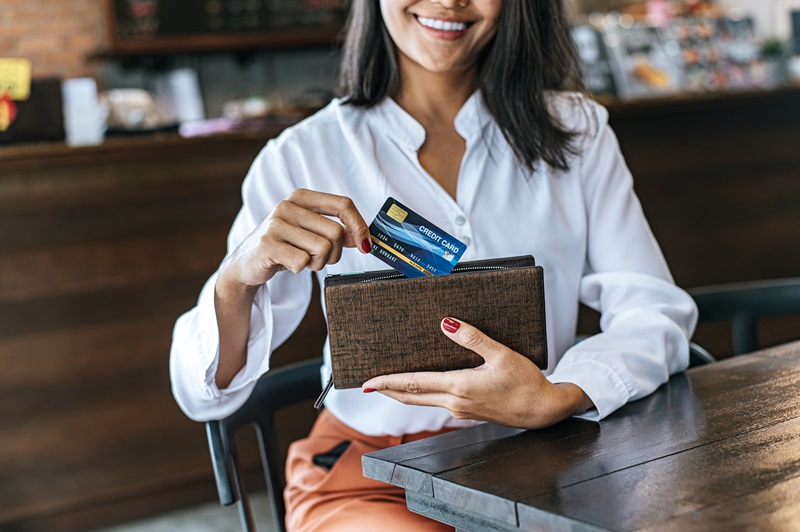 Mulher segurando um cartão de crédito