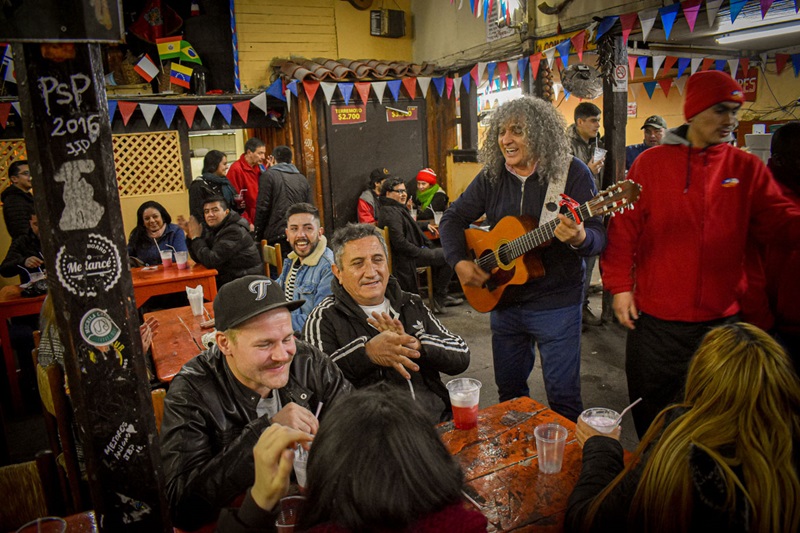 Pessoas curtindo o bar La Piojera em Santiago